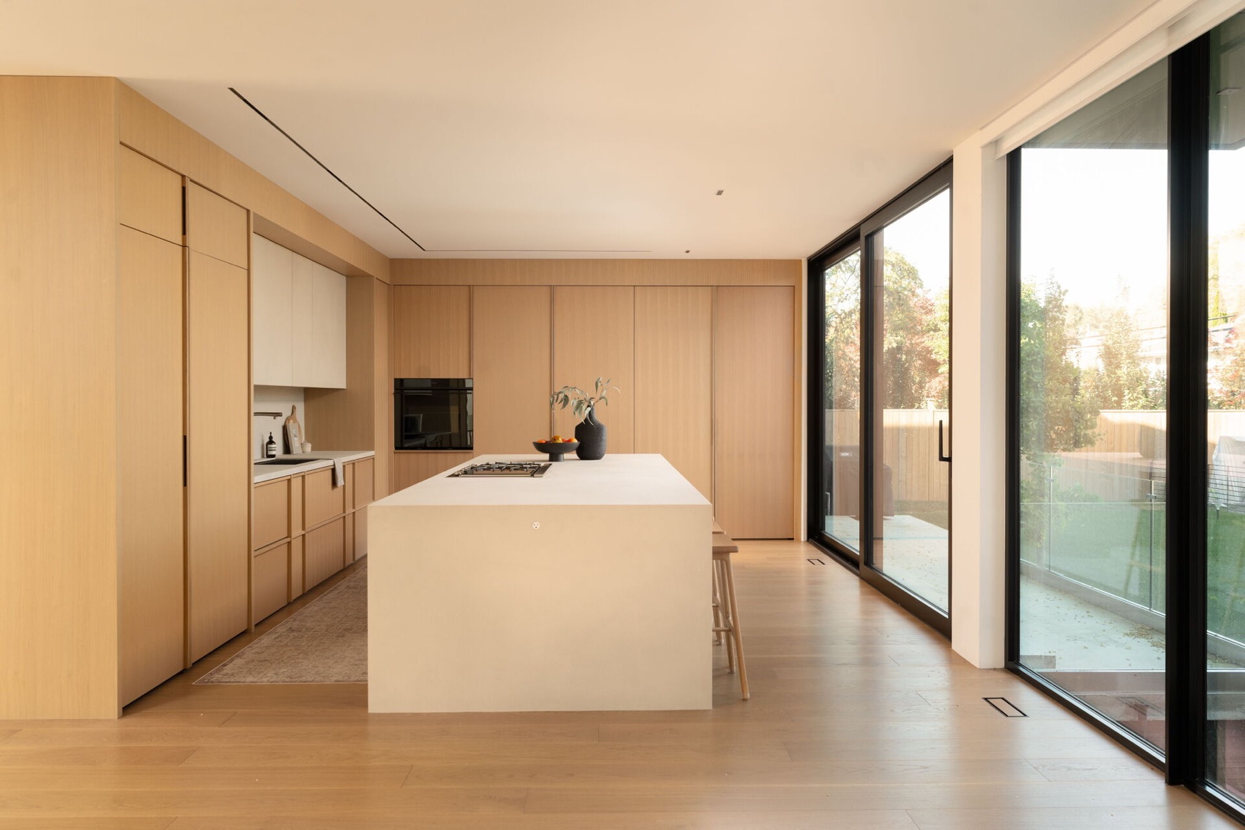 Minimal natural-wood kitchen with integrated linear ceiling lighting